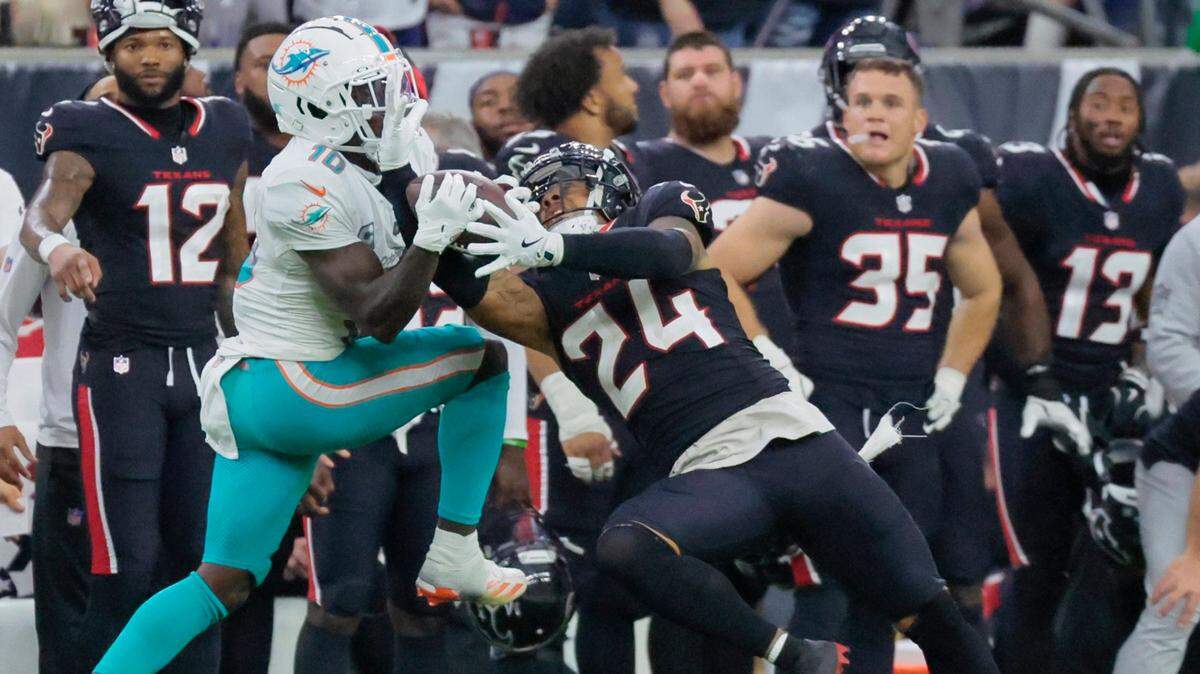 El cornerback de los Texans Derek Stingley Jr. (der.) trata de quitarle el balón al wide receiver de los Dolphins de Miami Tyreek Hill, en el partido celebrado el 15 de diciembre de 2024 en Houston.