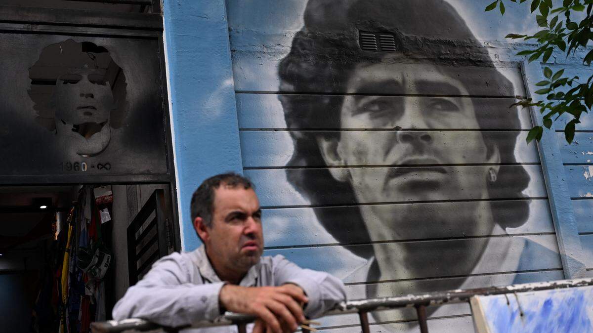 Un hombre permanece junto a un mural del fallecido ídolo argentino del fútbol Diego Maradona, afuera del estadio Diego Armando Maradona, sede del club Argentinos Juniors, en el barrio La Paternal de Buenos Aires, el 2 de diciembre de 2025.