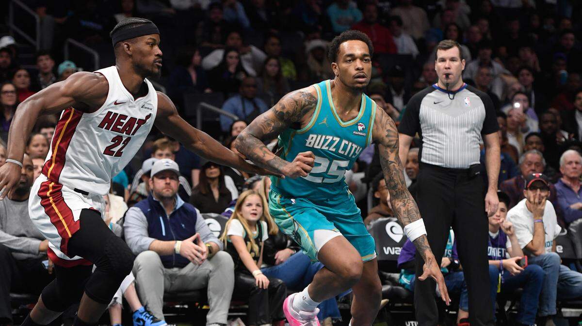 El jugador de los Hornets P.J. Washington Jr. (der.) trata de pasar la marca de Jimmy Butler, del Heat de Miami, en el partido celebrado el 14 de noviembre de 2023 en Charlotte.