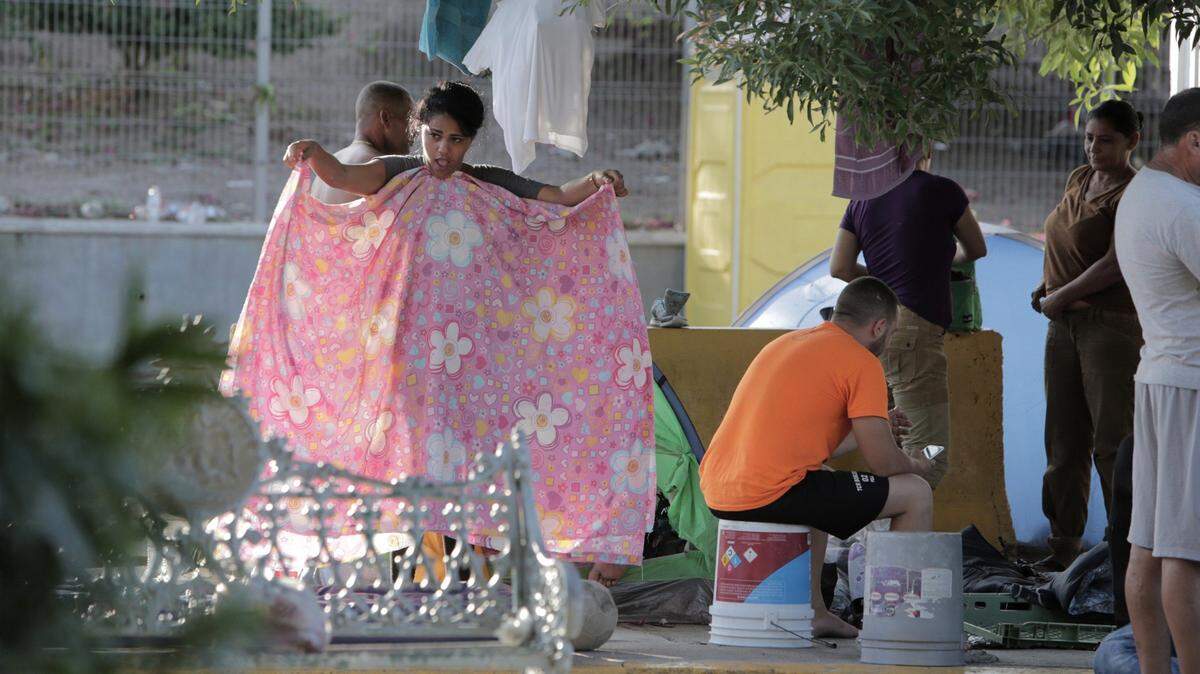 Matamoros, México, 30 de julio de 2019 - Migrantes cubanos que duermen en un pequeño campamento al lado del Puente Internacional en Matamoros, México, se preparan para enfrentar otro día de espera para solicitar asilo político en los Estados Unidos. Gateway International Bridge es uno de los tres puentes internacionales que cruzan la frontera entre Estados Unidos y México entre las ciudades de Brownsville, Texas y Matamoros, Tamaulipas.