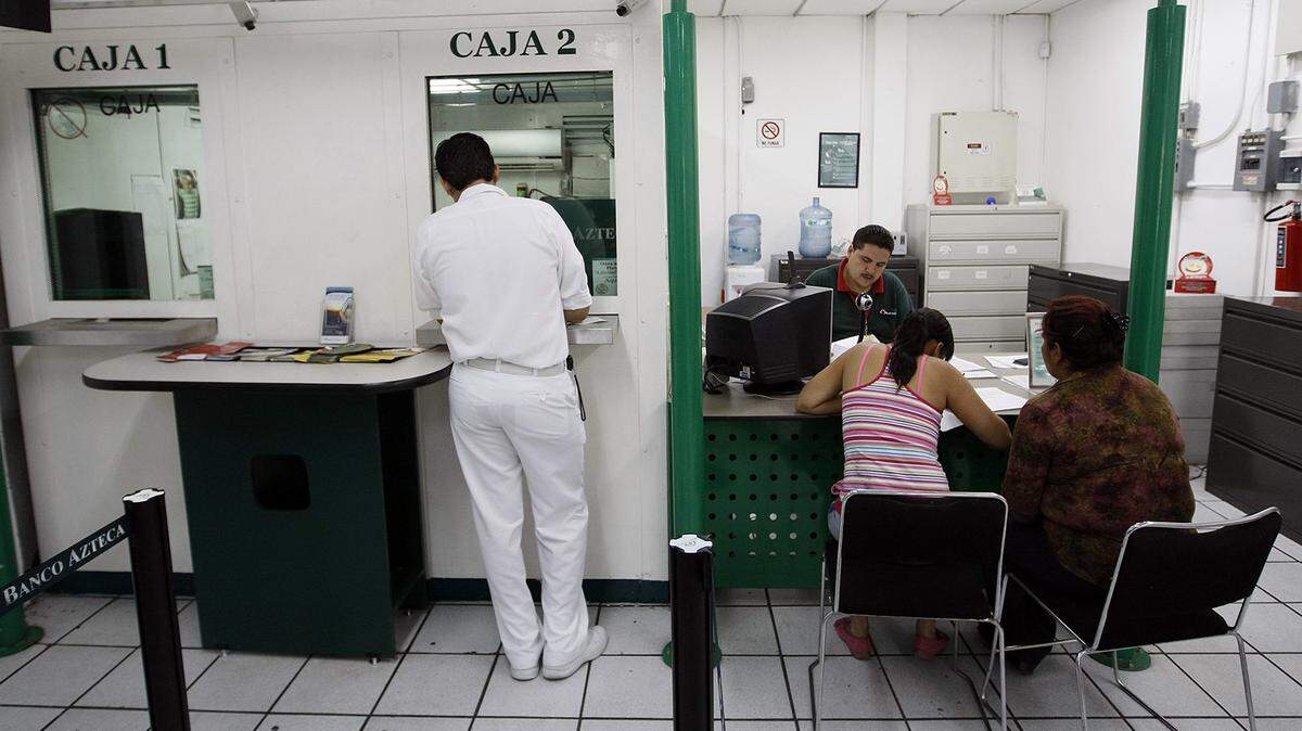 Los residentes hacen fila en la sucursal bancaria del Banco Azteca en Zamora, Michoacán, que maneja transferencias electrónicas por Western Union desde los EE UU.