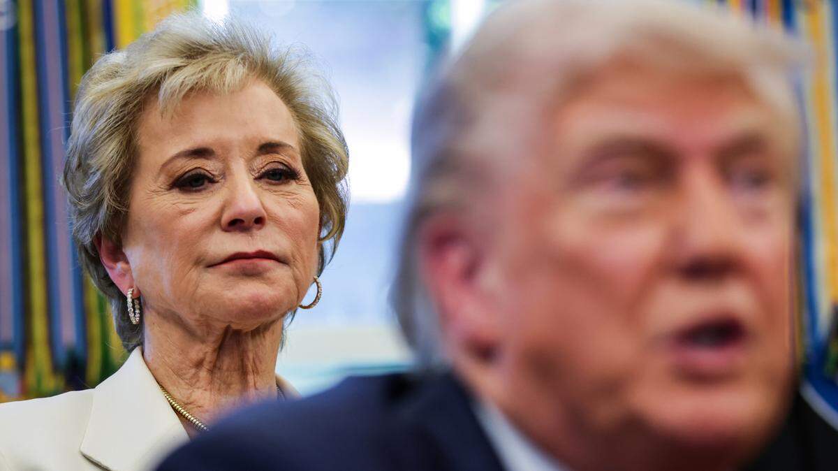 La secretaria de Educación, Linda McMahon, está detrás del presidente Donald Trump mientras responde preguntas de los periodistas después de firmar órdenes ejecutivas en la Oficina Oval de la Casa Blanca el 23 de abril de 2025 en Washington, D.C..