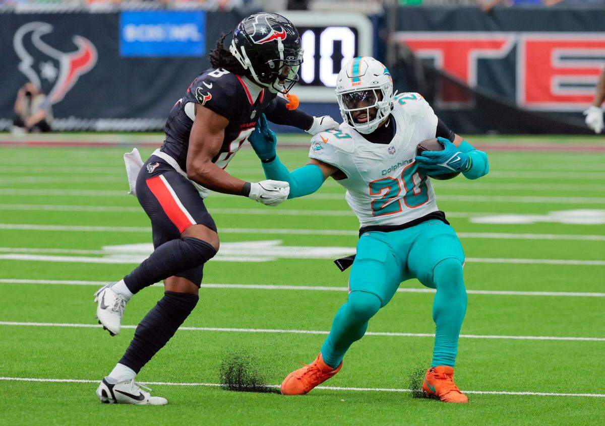 El linebacker de los Dolphins Jordyn Brooks (der.) trata de pasar la marca del wide receiver de los Texans John Metchie III, en el partido celebrado el 15 de diciembre de 2024 en el NRG Stadium en Houston, Texas.