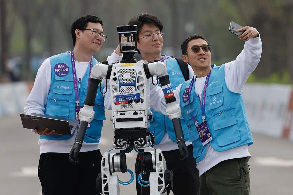 Más de 100 robots humanoides, procedentes de 76 instituciones de toda China, se alinearon el domingo junto a 12,000 corredores humanos en el distrito E-Town de Pekín para participar en la media maratón de robots humanoides más grande del mundo.