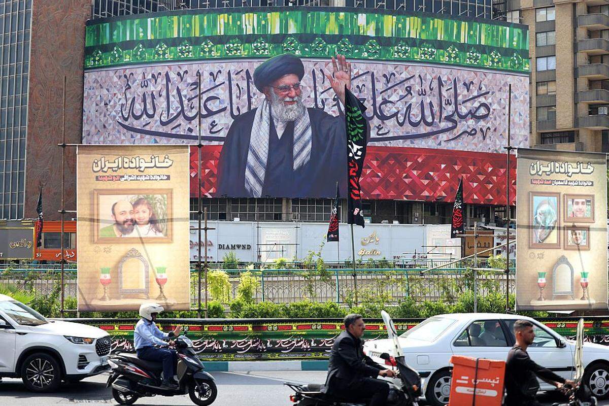 Automovilistas circulan con sus vehículos junto a una valla publicitaria que muestra al líder supremo de Irán, el ayatolá Ali Khamenei, ubicada en el centro de la plaza Valiasr de Teherán, el 13 de julio de 2025.