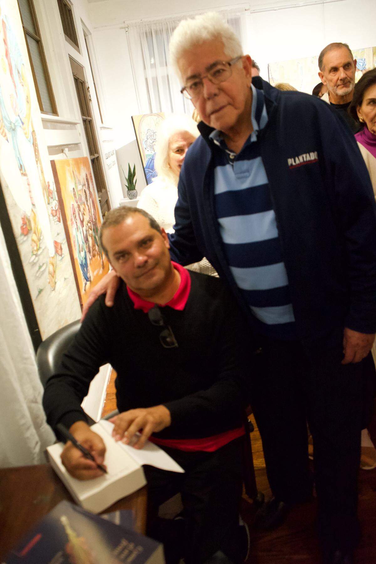 William Navarrete con Angel de Fana, uno de los entrevistados, en la presentación de ‘Como el ave fénix’, en el Hispanic Cultural Arts Center de Miami en enero de 2025.