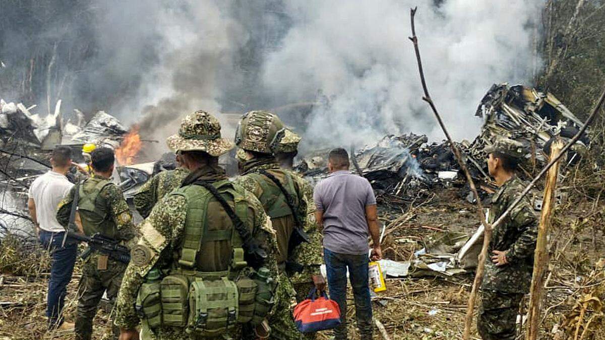 Esta imagen tomada de un video muestra a personal de rescate, militares y civiles en el lugar donde se estrelló un avión militar Hercules de la Fuerza Aérea de Colombia, en Puerto Leguizamo, el lunes 23 de marzo de 2026.