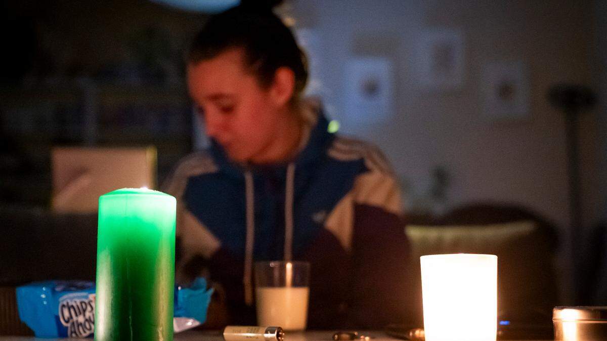 Una mujer se ilumina dentro de su casa con la ayuda de velas y luces a batería durante el apagón general, en Madrid, el 28 de abril de 2025.