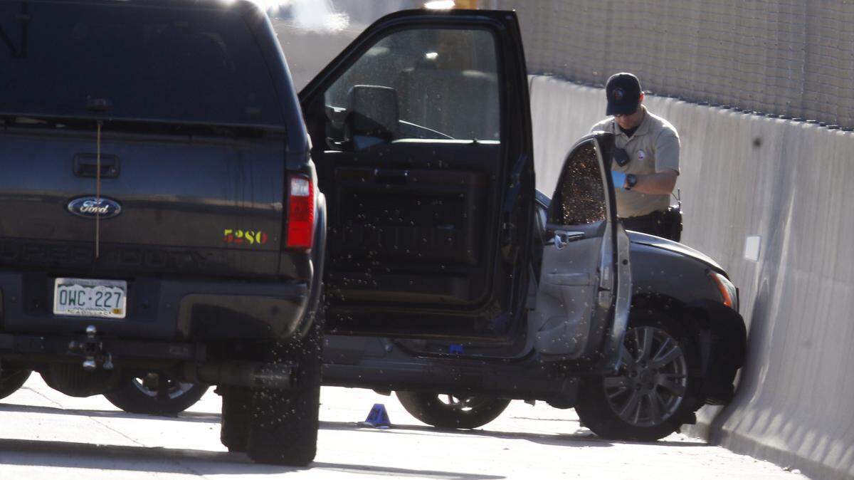 Agentes de la Policía de Denver investigan en la escena del crimen después de que el chófer de Uber le dispara a su pasajero el viernes. 
 (AP Photo/David Zalubowski)