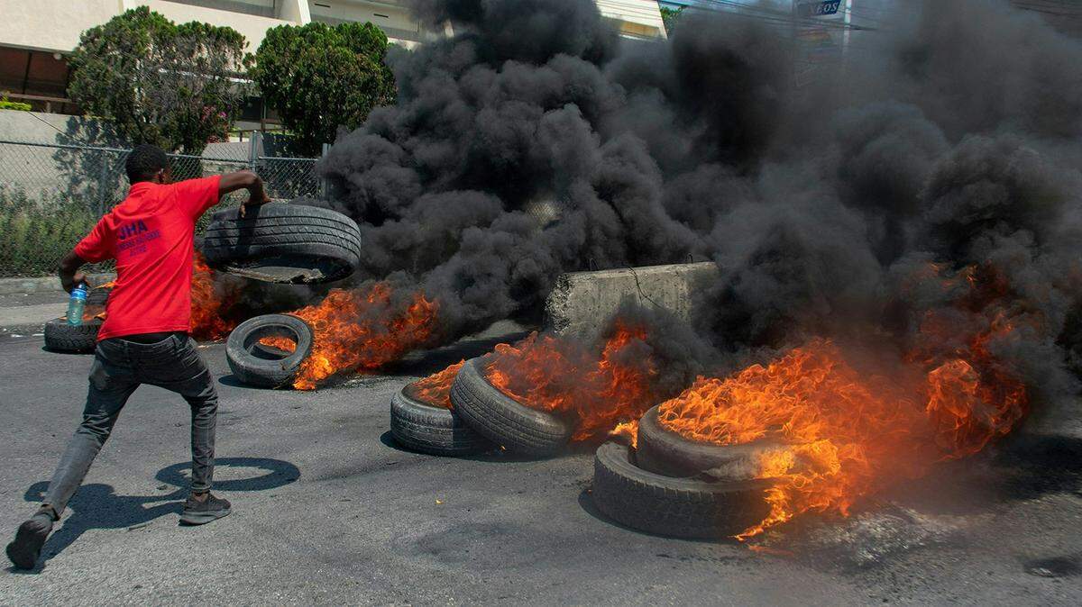 A protester burns tires during a demonstration following the resignation of its Prime Minister Ariel Henry, in Port-au-Prince, Haiti, on March 12, 2024. A political transition deal in Haiti marks a key step forward for the violence-ravaged country but far more needs to be done, with some experts warning the situation could deteriorate further. (Clarens Siffroy/AFP via Getty Images/TNS)