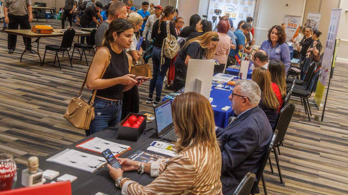 Raquel Espinoza se informa en la mesa de Miami Media School en una feria comunitaria en Hialeah, en septiembre del 2023. El jueves 25 de abril se celebra en Sunrise una feria de trabajo, Mega South Florida Job Fair, que contará con 50 compañías que estarán contratando para llenar 13,000 puestos en Miami-Dade, Broward y Palm Beach.