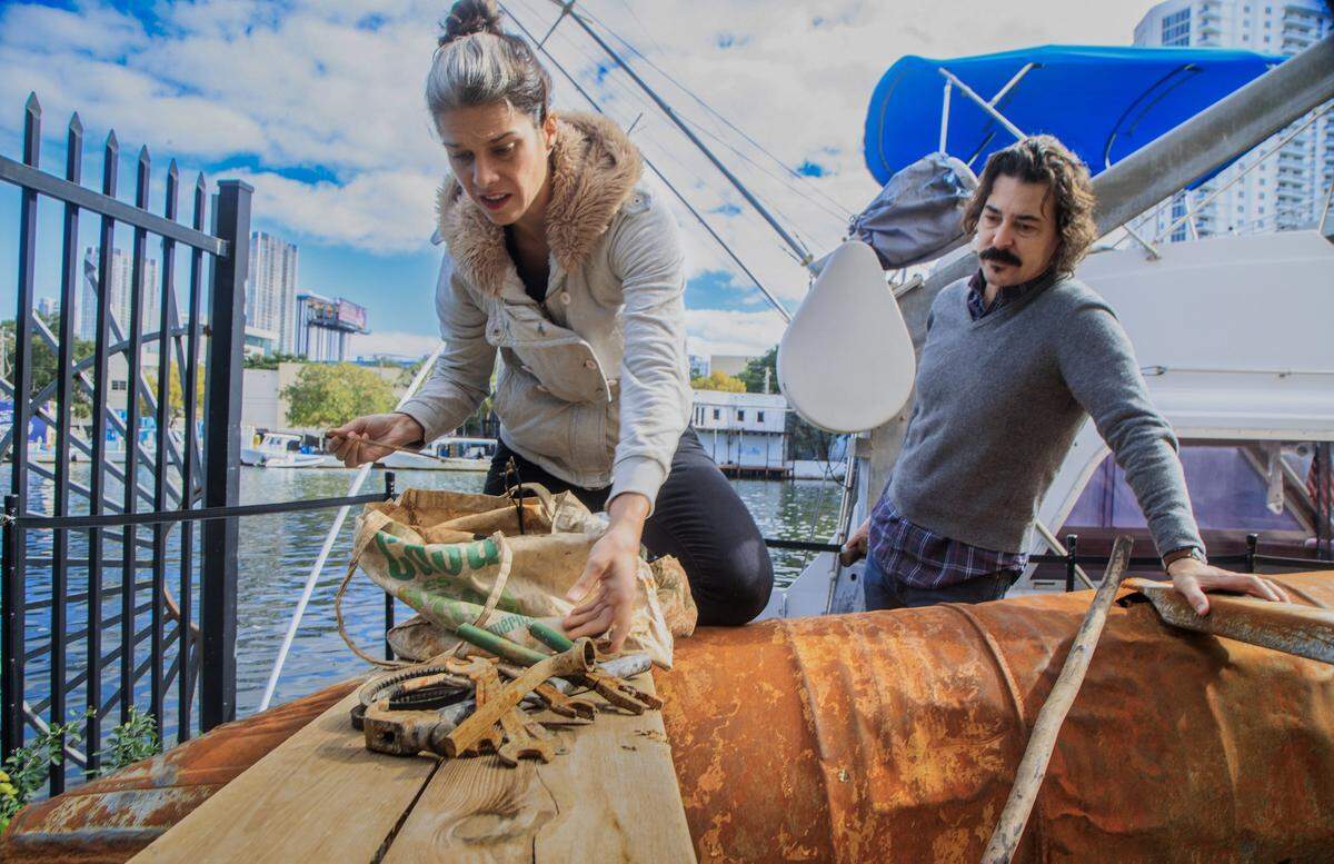 Los artistas cubanoamericanos Antonia Wright y Rubén Millares examinan objetos hallados en una balsa utilizada por cubanos que huían de la isla —recuperada tras haber encallado en Key Biscayne, Florida, y trasladada posteriormente a su estudio el 19 de enero de 2022. 