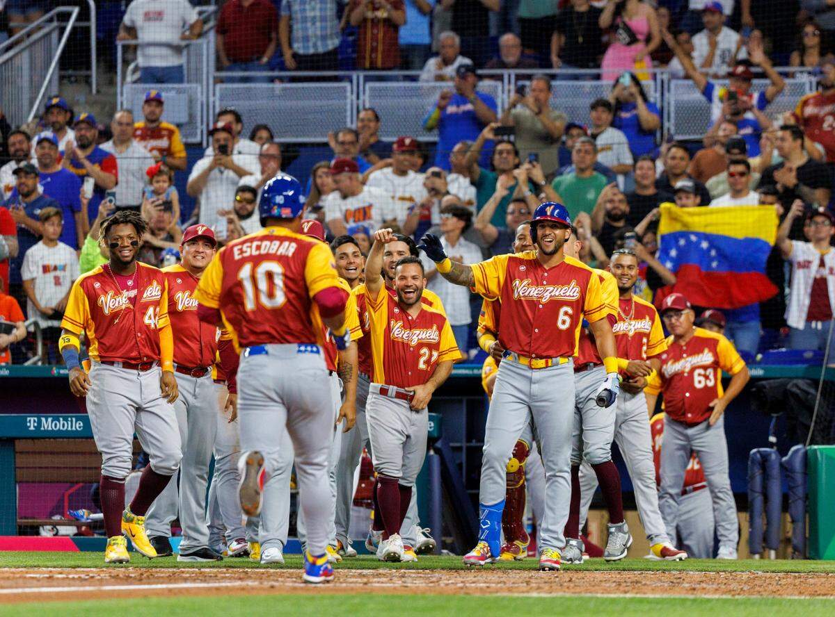 El tercera base de Venezuela Eduardo Escobar (10) es recibido por sus compañeros de equipo tras pegar un jonrón ante Israel, en el cuarto inning del partido del Grupo D del Clásico Mundial de Béisbol, celebrado el 15 de marzo de 2023 en Miami.