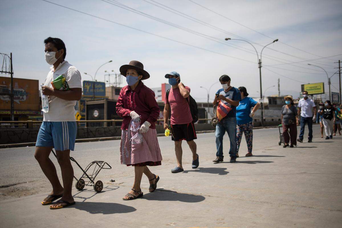Peruvians make lines to buy groceries in Lima.