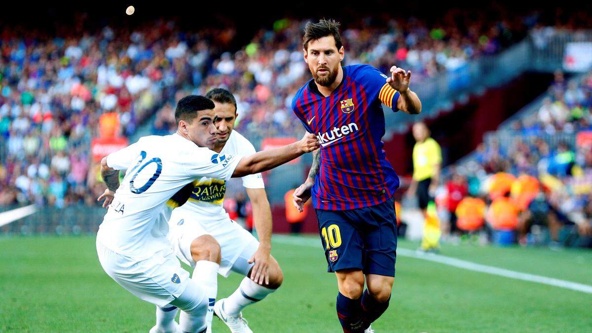 El delantero argentino del Barcelona Lionel Messi (der.) pelea un balón con el defensa de Boca Juniors Lucas Olaza durante el trofeo Joan Gamper, el 15 de agosto de 2018 en Barcelona.
