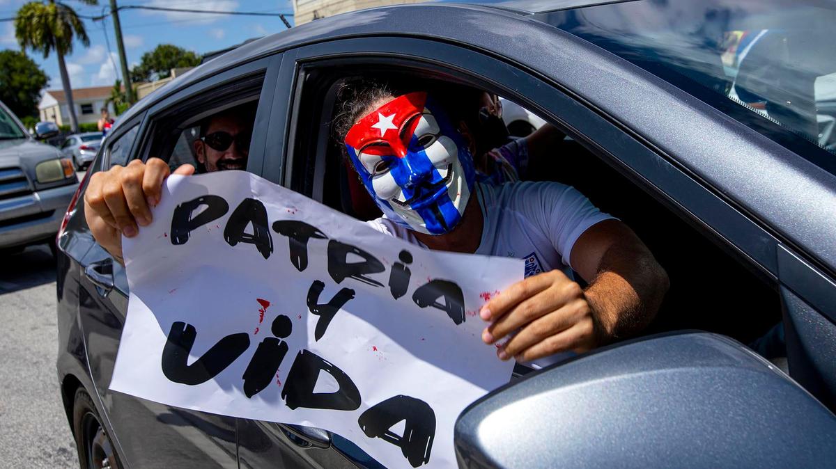 Un exiliado lleva una pancarta con el nombre de la canción Patria y Vida, que se ha convertido en un lema para los cubanos dentro y fuera de la isla, en una manifestación en la zona del restaurante Versailles, en la Calle Ocho, el 11 de julio.