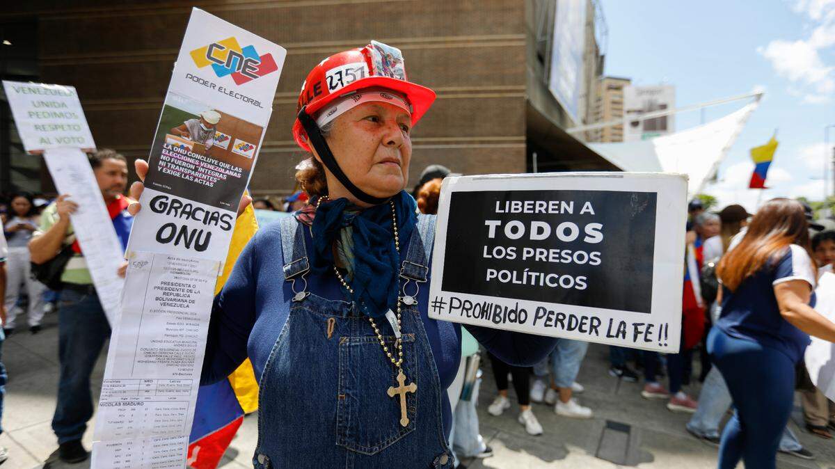 Una mujer sostiene una pancarta exigiendo que “Liberen a todos los presos políticos - Prohibido perder la fe”, durante una protesta el sábado 17 de agosto de 2024 en Caracas, Venezuela.
