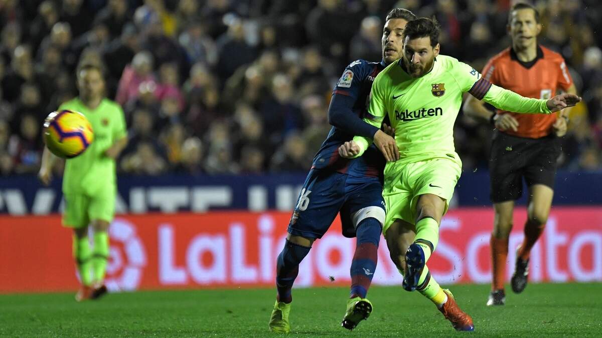 El delantero de Barcelona Lionel Messi (der.) dispara a puerta ante la marca de Rubén Rochina, del Levante, en el partido efectuado el 16 de diciembre de 2018 en Valencia.