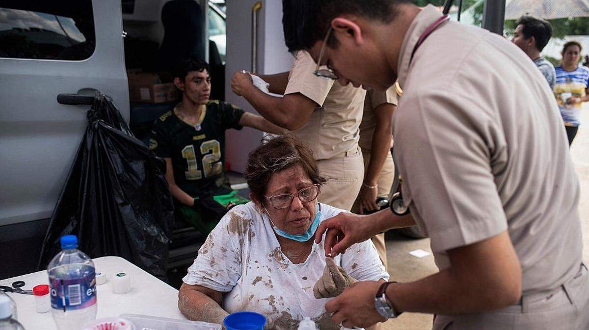 A woman receives medical attention in the municipality of Alamo, Veracruz state, Mexico on October 12, 2025. The death toll from heavy rains in Mexico rose to 44 after the Mexican government confirmed three more fatalities on Sunday, as civilian and military rescuers struggle to clear roads and reach cut-off communities. (Photo by Hector Quintanar / AFP) (Photo by HECTOR QUINTANAR/AFP via Getty Images)          
