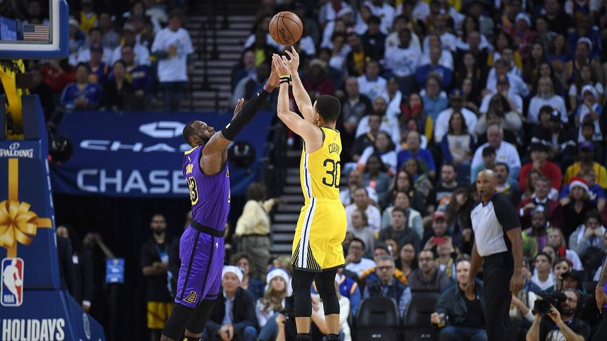 Stephen Curry (der.) tira al aro por los Warriors ante la marca de LeBron James, de los Lakers, en el partido celebrado el 25 de diciembre de 2018 en Oakland.
