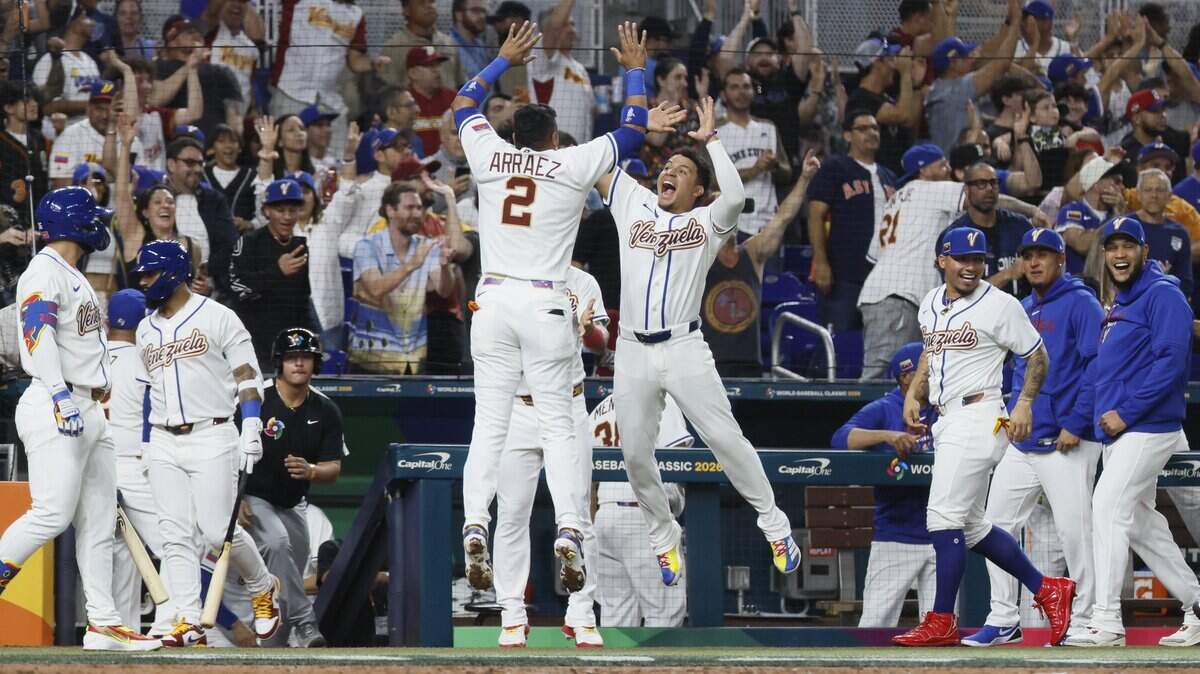 El primera base venezolano Luis Arraez (2) celebra con sus compañeros de equipo tras anotar con un sencillo remolcador del receptor Salvador Pérez, en la primera entrada del partido contra Israel en el  Clásico Mundial de Béisbol, efectuado el 7 de marzo de 2026 en el loanDepot Park de Miami. 