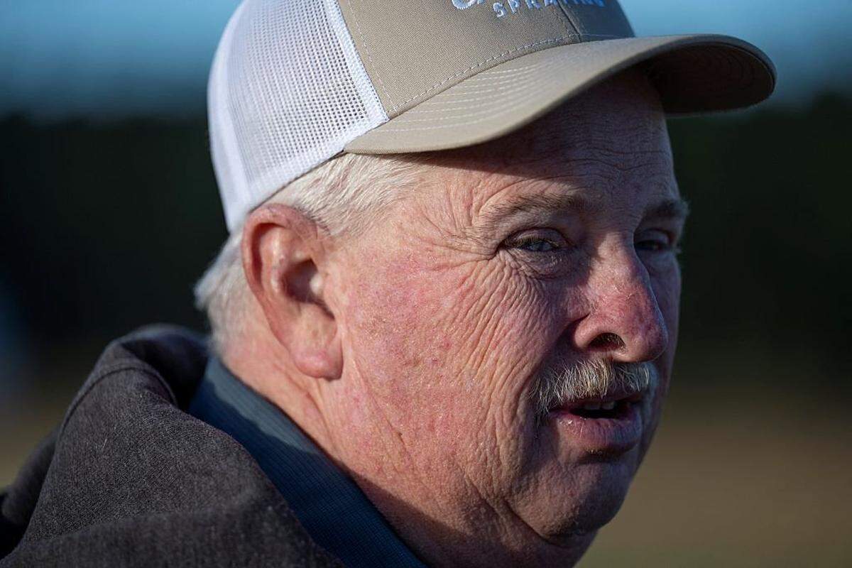 Travis Hutchison, a soybean farmer, stands near a field of soybeans ready for harvesting at his family's farm in Cordova, Maryland, on October 10, 2025. The US soybean harvest is underway and in rural Maryland, farmer Travis Hutchison cracks open a pod to show how a field is nearly dry enough for reaping. But a decent yield is not enough to secure his income this year -- with China, once the biggest buyer of US soybean exports, halting orders in a trade row triggered by President Donald Trump's aggressive tariffs. Soybean prices "are really depressed because of the trade war," Hutchison told AFP. His family tills 3,400 acres of soybeans, corn and other crops. (Photo by ROBERTO SCHMIDT / AFP) (Photo by ROBERTO SCHMIDT/AFP via Getty Images)          