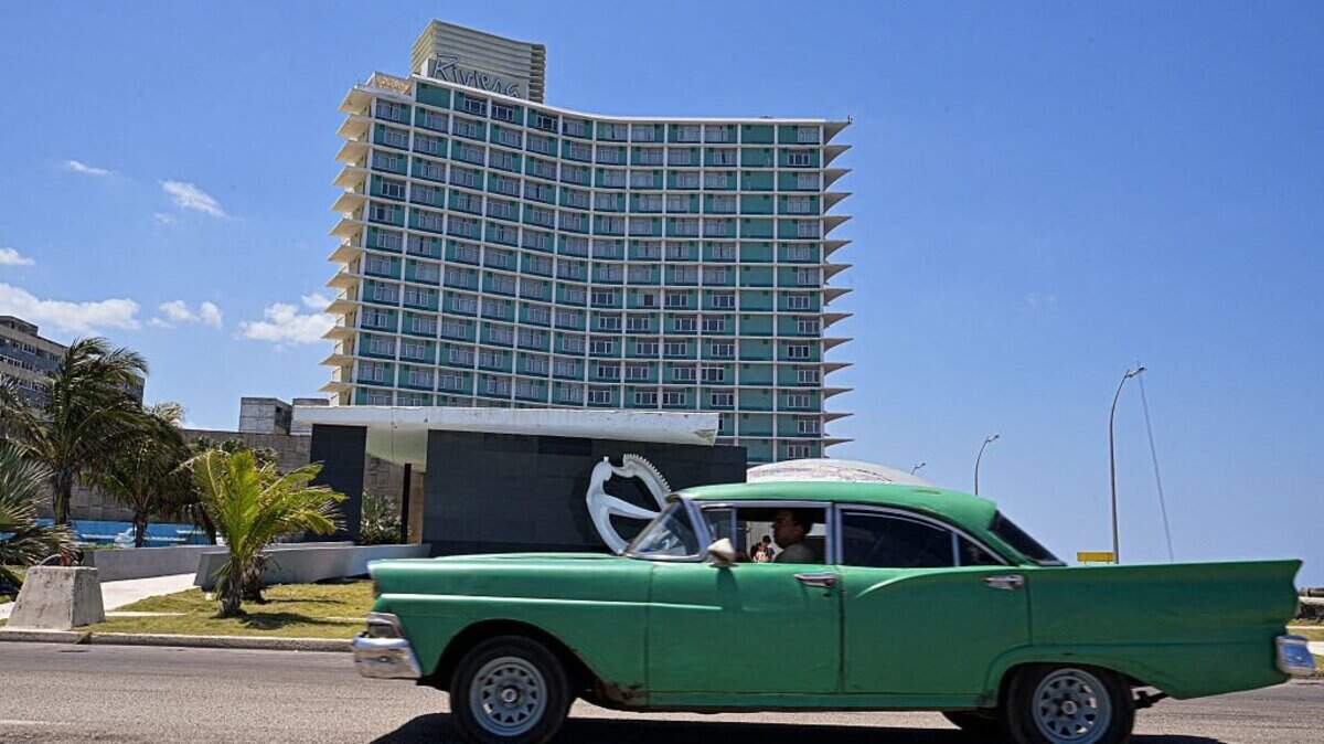 A 1950s classic car drives past the Riviera Hotel in Havana on April 14, 2025. "La bolita," the clandestine lottery that multiplies its followers in the midst of the strong economic crisis in Cuba, has survived 66 years of prohibition on the communist island. With the triumph of the Cuban Revolution, all gambling was banned and casinos were closed, sanctioning any kind of game for money until the present day. (Photo by ADALBERTO ROQUE / AFP) (Photo by ADALBERTO ROQUE/AFP via Getty Images)