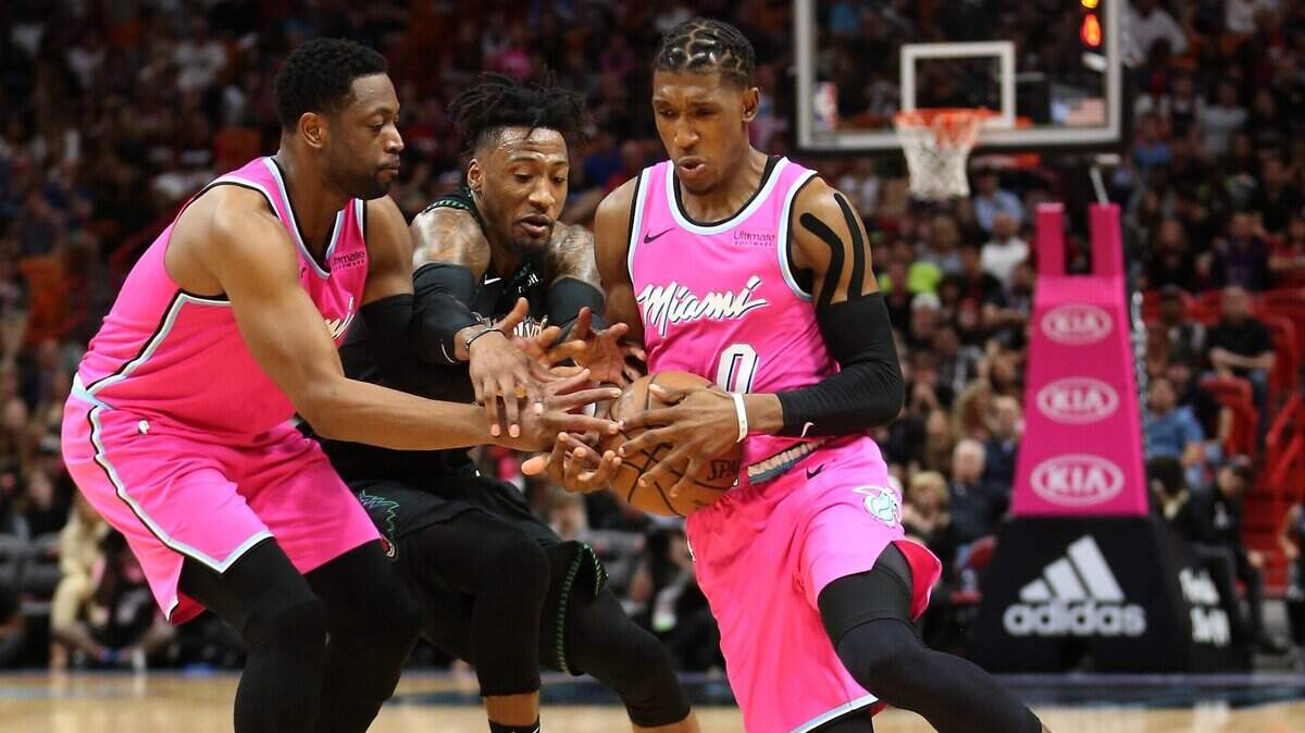 Dwyane Wade (izq.) y Josh Richardson le arrebatan el balón al jugador de los Timberwolves Robert Covington, en el último cuarto del partido celebrado el 30 de diciembre de 2018 en Miami.