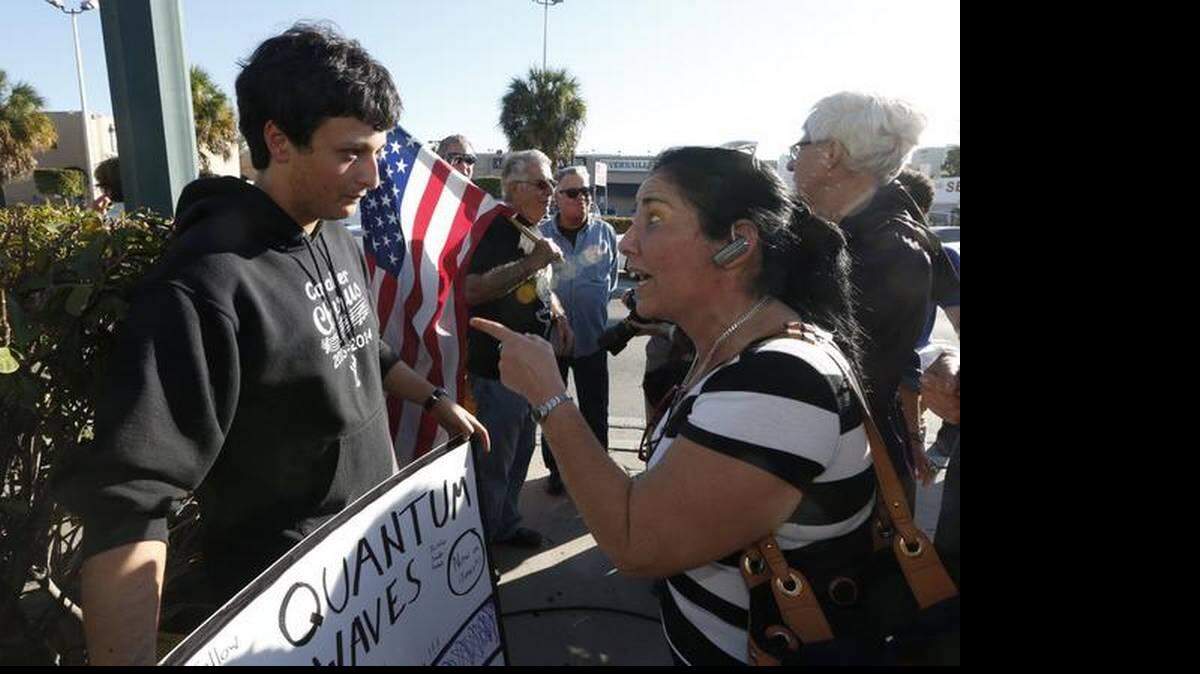 Una mujer no identificada discute con Bryan Medina por su cartel de felicitaciones en el restaurante Versailles en Miami el miércoles, 17 de diciembre 2014, tras el anuncio del presidente Barack Obama de que EEUU normalizará las relaciones con Cuba. 