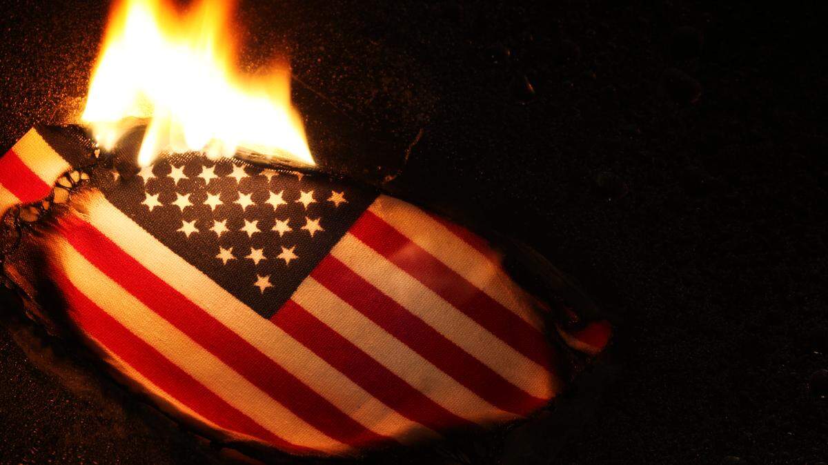 Un hombre fue arrestado el lunes en la noche frente a la Casa Blanca tras quemar una bandera de EEUU en protesta contra la orden del presidente Donald Trump de prohibir estas acciones. (Ilustración de Getty Images)
