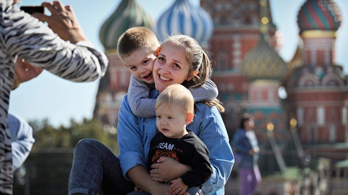 Una familia posa para una foto en la Plaza Roja frente a la Catedral de San Basilio en el centro de Moscú el 10 de septiembre de 2025.