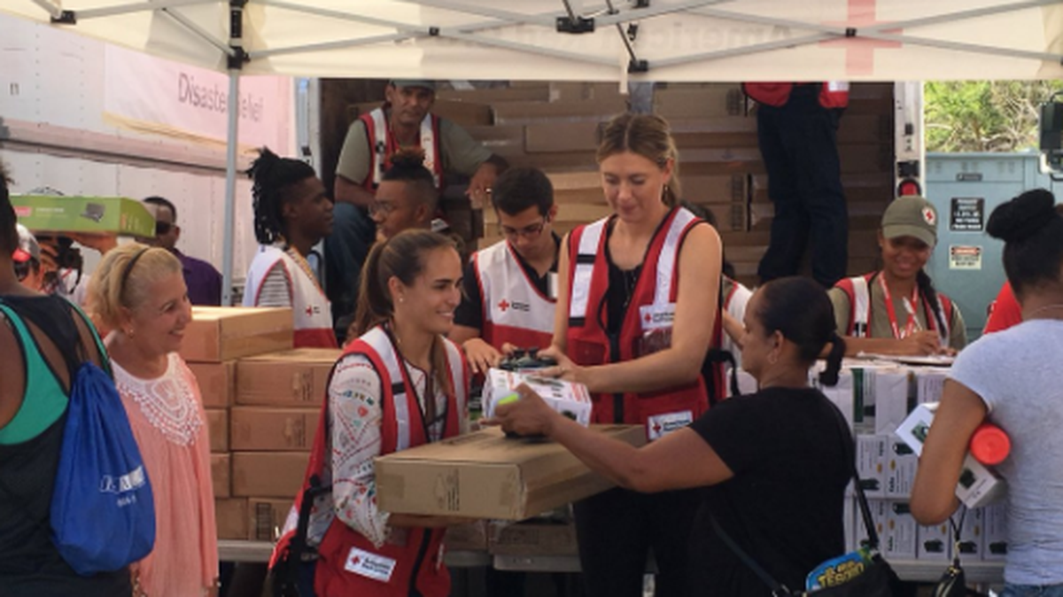 Monica Puig (izq.) y Maria Sharapova con la población de Loíza, Puerto Rico, donde entregaron ayuda humanitaria, el 23 de octubre del 2017. 