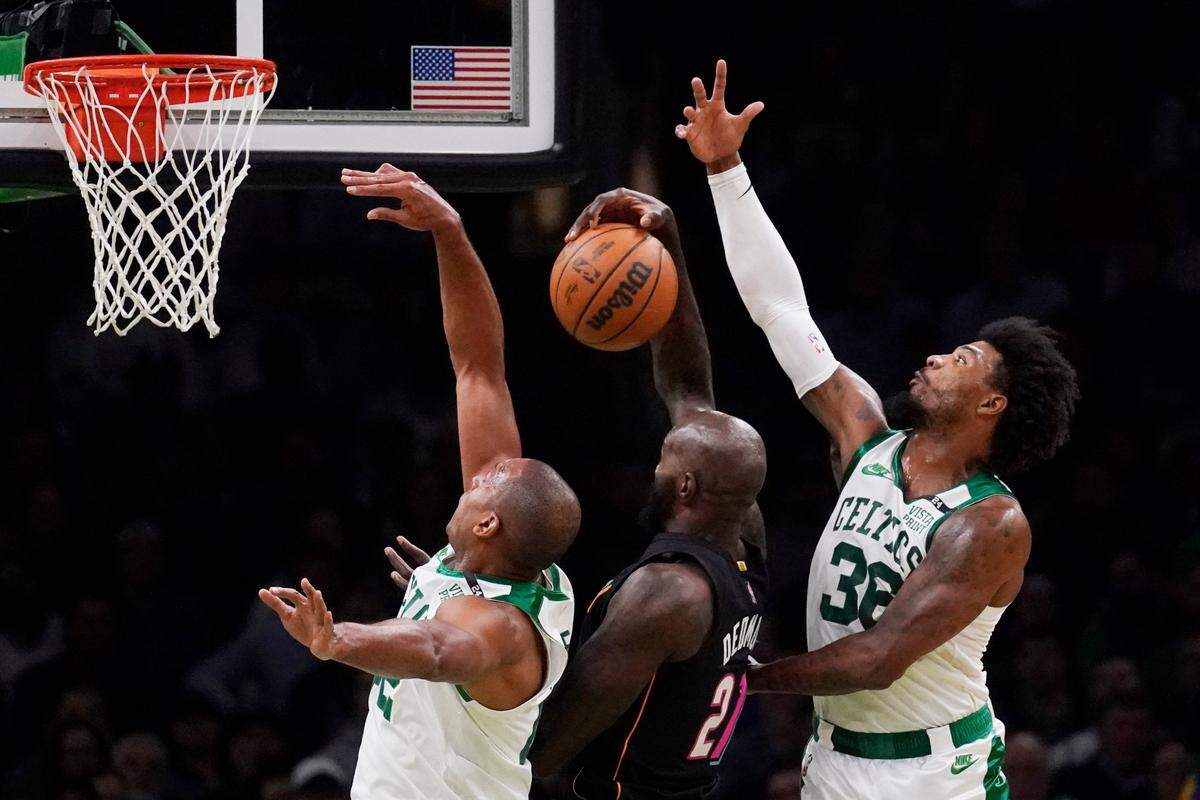 El centro del Heat de Miami Dewayne Dedmon consigue el rebote ante la defensa de Marcus Smart (36) y Al Horford, en el partido celebrado el 30 de marzo de 2022 en Boston.