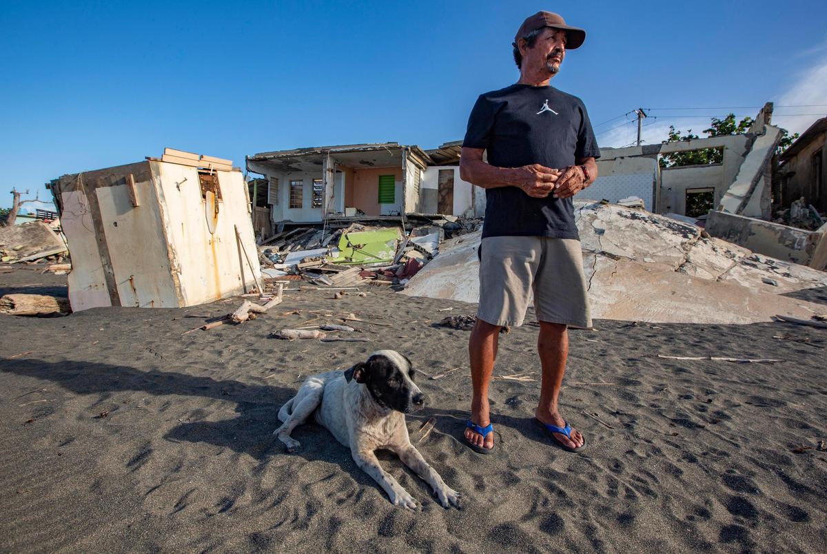 Durante el paso del huracán María por Puerto Rico, el mar arrasó con la vivienda de Rafael Rosario Quintero, de 70 años y pescador que vive en la costa de La Boca en Barceloneta. En esta imagen se ve a Quintero junto a su perro, llamado Capitán, y lo que queda de la casa detrás.