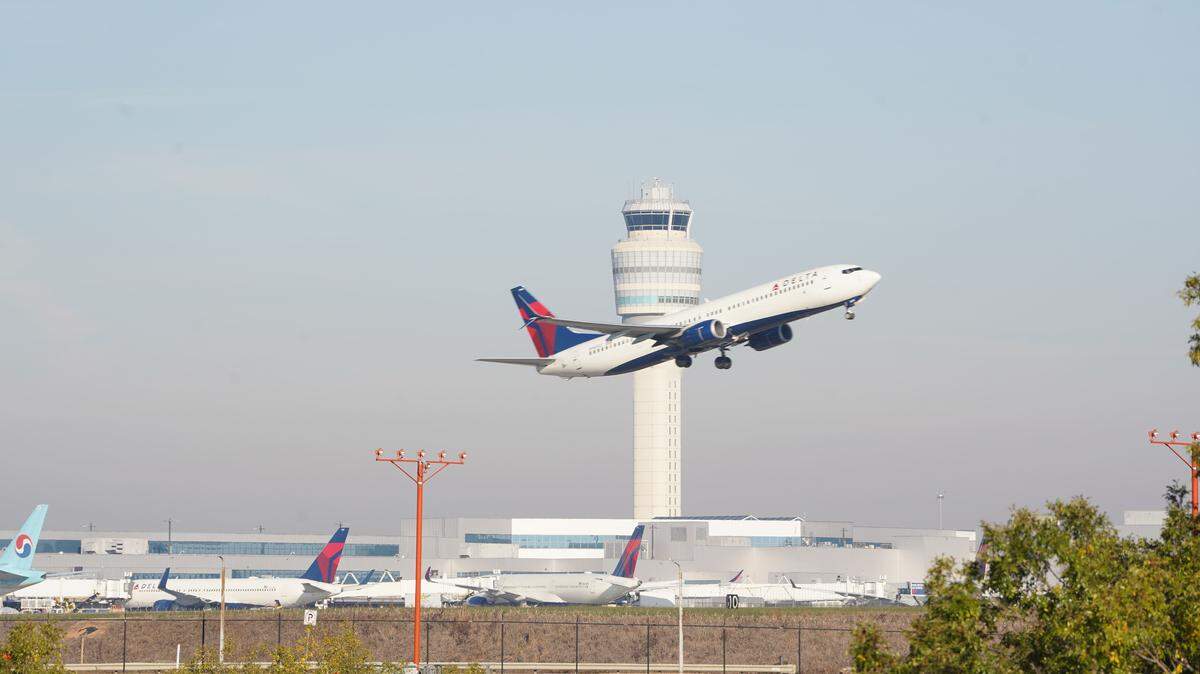 ATLANTA, GEORGIA - NOVEMBER 7: A plane flies past the air traffic control tower as people travel through Hartsfield-Jackson Atlanta International Airport on November 7, 2025 in Atlanta, Georgia. Today marks day 38 of the government shutdown. (Photo by Megan Varner/Getty Images)