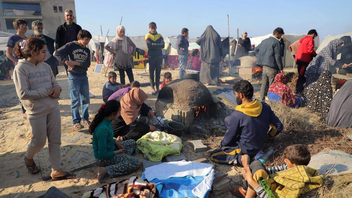 Palestinos desplazados por la guerra de Israel contra Hamás preparan comida en un refugio temporal, en Rafah, sur de Gaza, el domingo 24 de diciembre de 2023.