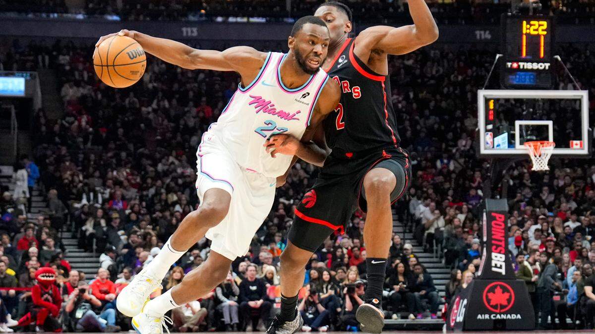 El delantero del Miami Heat, Andrew Wiggins (22), dribla el balón contra el delantero de los Toronto Raptors, Jonathan Mogbo (2), durante la primera mitad en el Scotiabank Arena, el 21 de febrero de 2025; en Toronto.