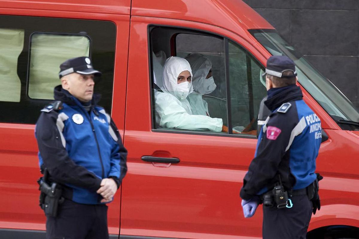 Miembros de la Unidad de Emergencia Militar (UME) toman camionetas de personas fallecidas para su almacenamiento en frío en la pista de hielo del Palacio de Hielo el 24 de marzo de 2020 en Madrid, España.
