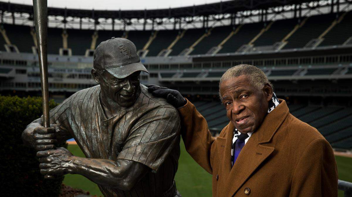 Orestes Miñoso posa junto con su estatua situada en el U.S. Cellular Field de Chicago, el 14 de noviembre de 2014.