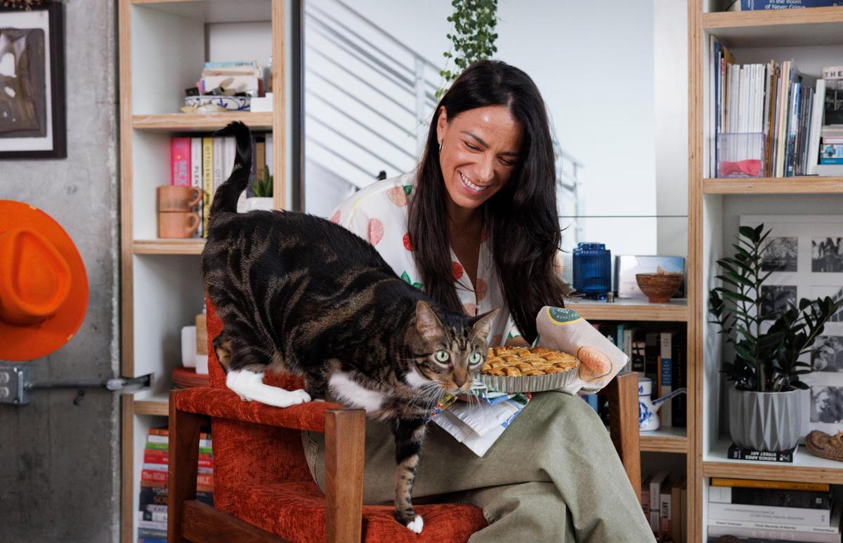 Natalia Martínez-Kalinina con una de sus tartas de mango y su gato, Pushkin, en su casa de Miami.