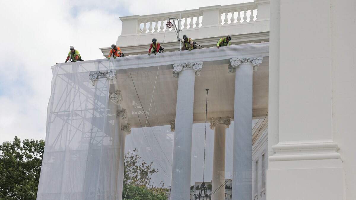 Trabajadores de la construcción colocan una lona sobre el andamio que rodea las columnas del Pórtico Norte de la Casa Blanca el 9 de julio de 2026 en Washington, D.C.