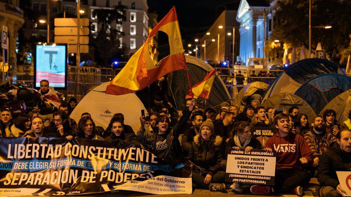 Decenas de manifestantes muestran banderas y pancartas cerca del Congreso en Madrid, el domingo 12 de noviembre de 2023.