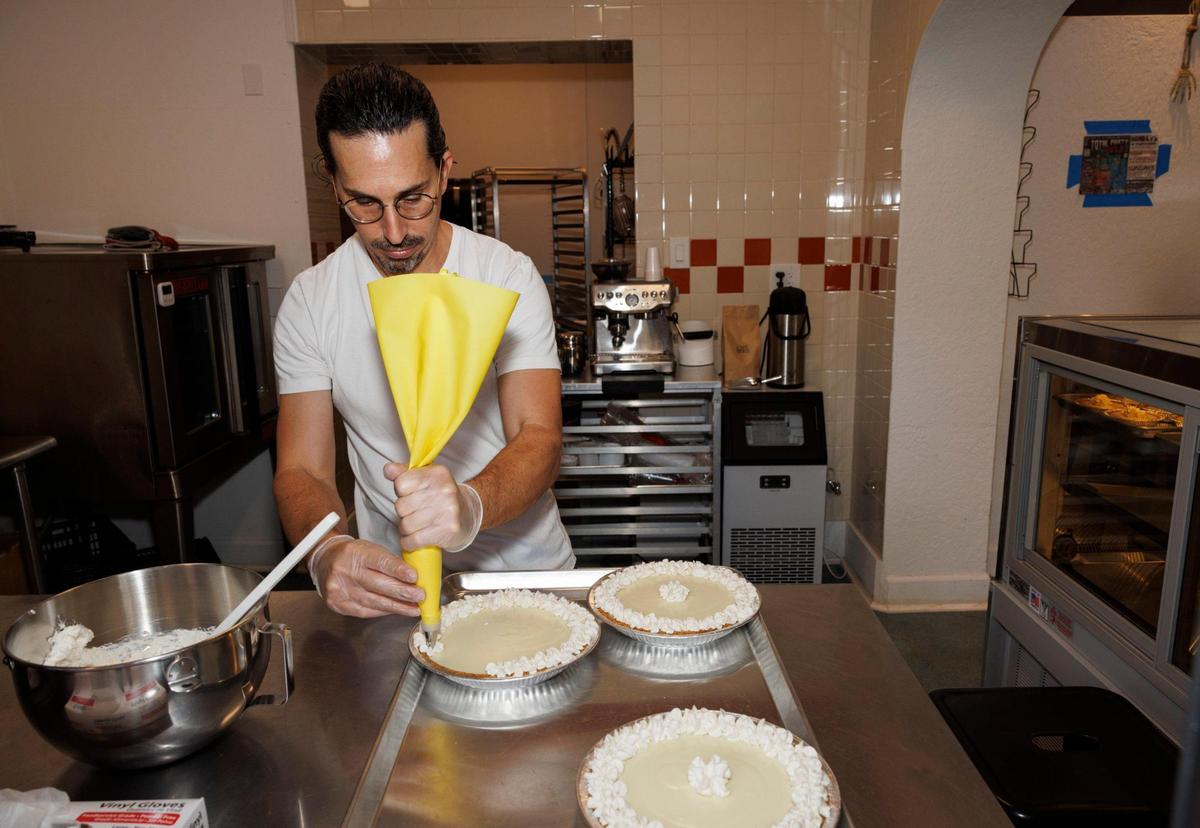 Joshua Abril cubre los key limes con crema batida en su nueva tienda de tartas en Coconut Grove. tienda.