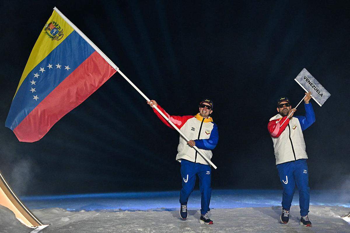 Nicolás Claveau-Laviolette sostiene la bandera de Venezuela durante la ceremonia inaugural de los Juegos Olímpicos de Invierno de Milán-Cortina, Italia, el 6 de febrero de 2026. 