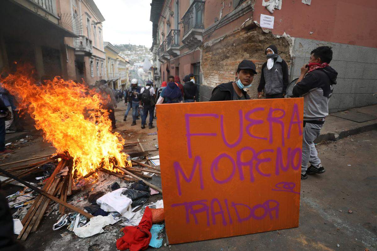 Una manifestante antigubernamental sostiene un cartelón contrario al presidente Lenín Moreno durante enfrentamientos con la policía en el centro de Quito, capital de Ecuador, este miércoles 9 de octubre de 2019.