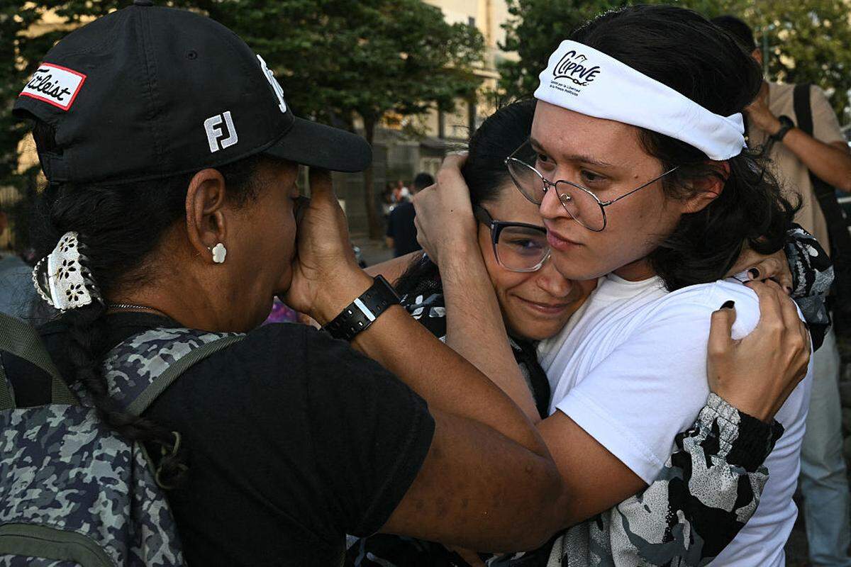 Miembros del Comité para la Libertad de los Presos Políticos (CLIPPVE) hacen gestos cerca de la entrada de El Helicoide, una instalación y prisión propiedad del gobierno venezolano y utilizada tanto para presos comunes como políticos del Servicio Bolivariano de Inteligencia Nacional (SEBIN), en Caracas, el jueves 8 de enero de 2026.
