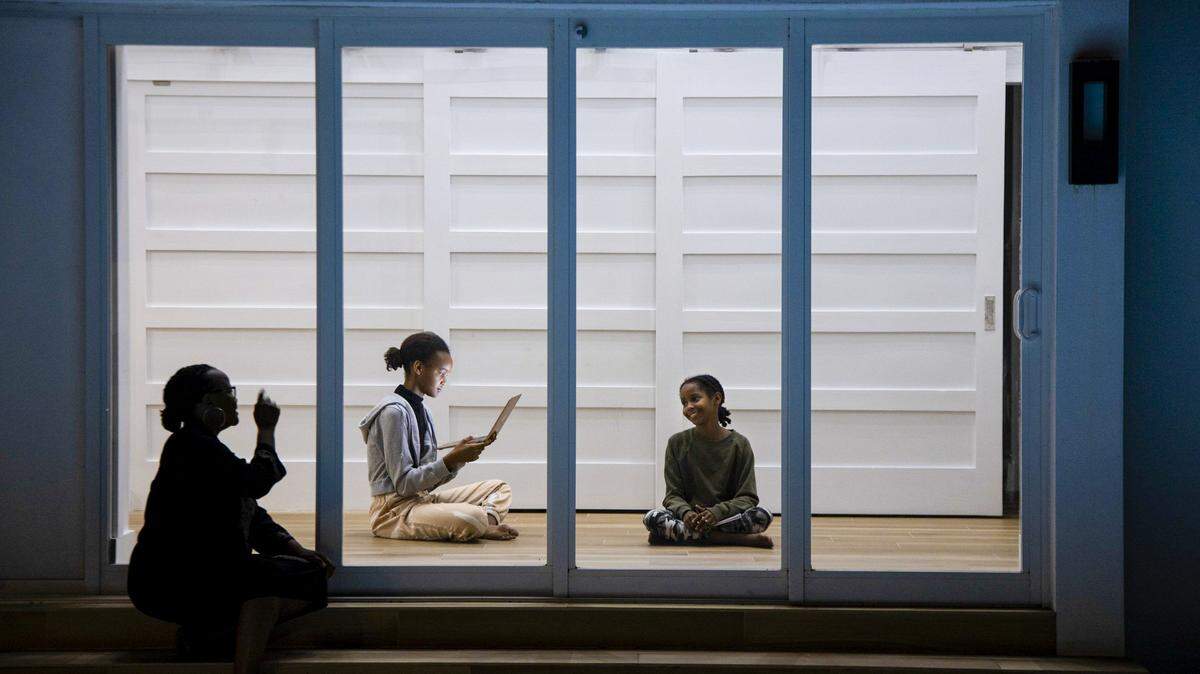La autora haitiano-estadounidense Edwidge Danticat y sus hijas, Mira, centro y Leila, han estado refugiadas en el lugar y practicando distanciamiento social durante las últimas tres semanas en su residencia de Miami. En esta imagen, Danticat intenta llamar la atención de Leila, mientras está sentada en su patio trasero durante la pandemia de COVID-19 el miércoles 1 de abril de 2020.