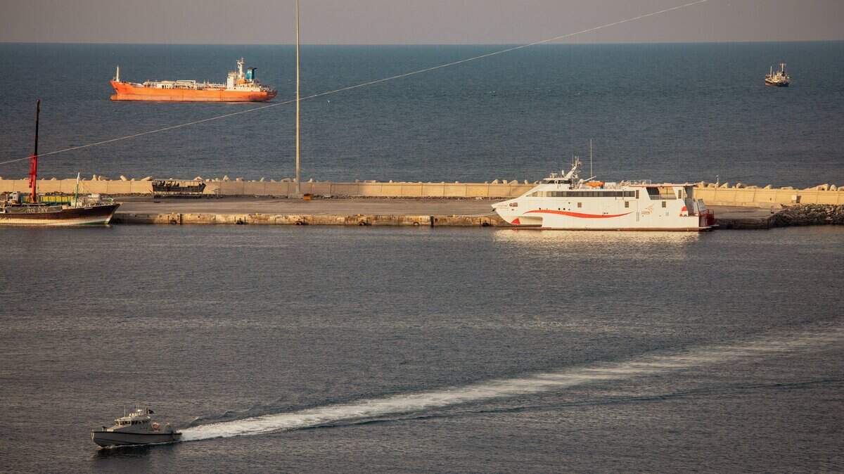 Una lancha rápida de la policía patrulla el puerto mientras petroleros y embarcaciones de alta velocidad permanecen anclados en el fondeadero de Mascate, cerca del estrecho de Ormuz, el 30 de marzo de 2026 en Mascate, Omán.