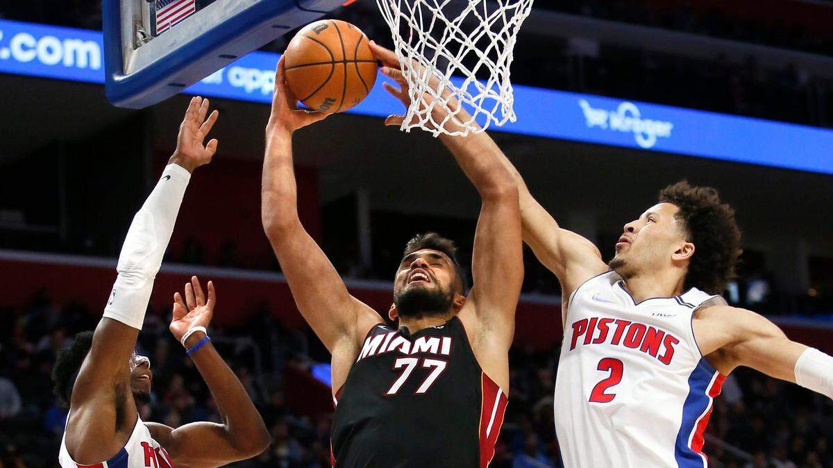 El centro del Heat Omer Yurtseven (77) entra al aro ante la marca de Hamidou Diallo (6) y Cade Cunningham (2), de los Pistons, en el partido celebrado el 19 de diciembre de 2021 en Detroit.
