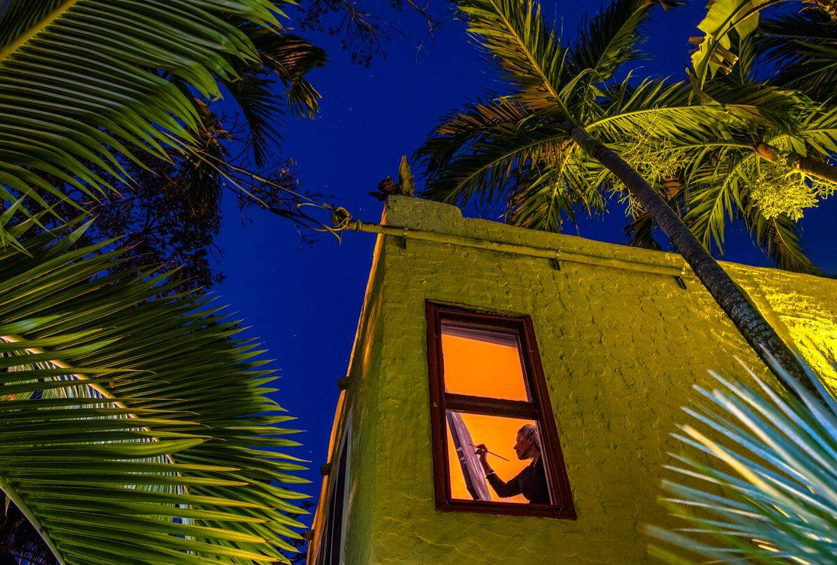 La artista Lisa Remeny trabaja hasta las horas del crepúsculo mientras practica el distanciamiento social mientras pinta “Moonlight on the coast” en su casa de Coconut Grove durante la pandemia de COVID-19 el miércoles 1 de abril de 2020.